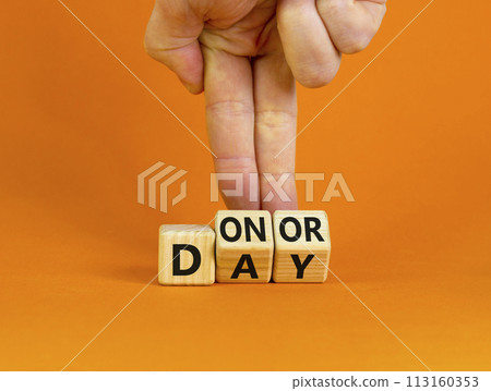 Donor day symbol. Doctor turns wooden cubes with words 'Donor day'. Beautiful orange background. Donor day and medical concept. Copy space. Donor day symbol. Doctor turns wooden cubes with words 'Donor day'. Beautiful orange background. Donor day and medical concept. Copy space. 113160353