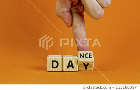 International Dance Day symbol. Dancer turns cubes with words 'dance day'. Beautiful orange table, orange background, copy space. International Dance Day concept. 113160357