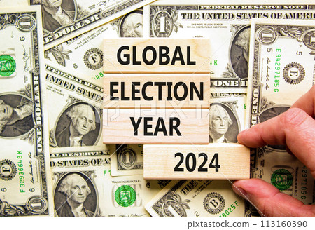Global election year 2024 symbol. Concept words Global election year 2024 on beautiful block. Beautiful dollar bills background. Voter hand. Business Global election year 2024 concept. Copy space 113160390