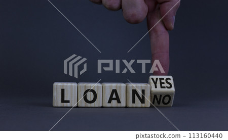 Loan yes or no symbol. Businessman turns a wooden cube and changes words loan no to loan yes. Beautiful grey table, grey background, copy space. Business and loan yes or no concept. Loan yes or no symbol. Businessman turns a wooden cube and changes words loan no to loan yes. Beautiful grey table, grey background, copy space. Business and loan yes or no concept. 113160440