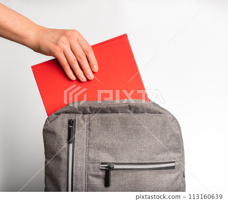 Hand taking red book, textbook from backpack, schoolbag 113160639
