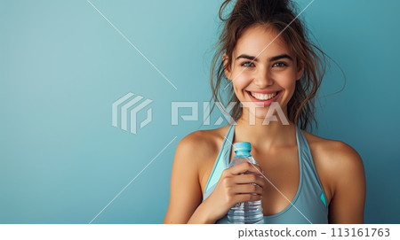Happy young woman in fitness clothing holding a bottle of water, active woman, banner, copy space 113161763