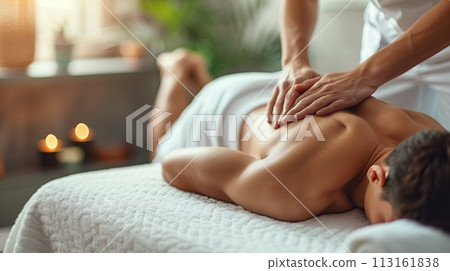 Relaxed young man receiving back massage in spa salon. Relaxing treatment concept 113161838