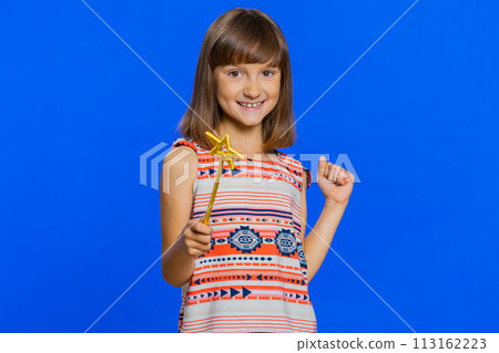 Child girl witch gesturing with magic wand fairy stick, making wish come true casting magician spell 113162223