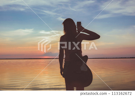 Joyful feeling satisfaction traveller, woman alone with acoustic guitar in summer time vacation leisure. pretty lady lifestyle. Joyful feeling satisfaction traveller, woman alone with acoustic guitar in summer time vacation leisure. pretty lady lifestyle. 113162672