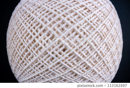 A close up of a white ball made of yarn 113162897