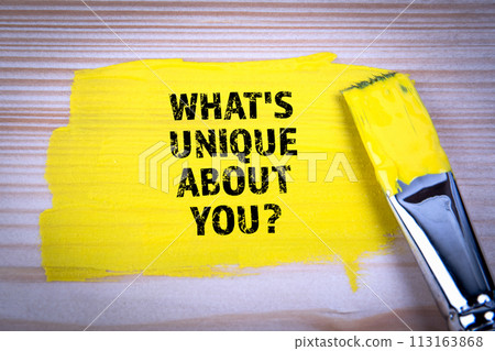 What's Unique About You. Yellow paint and paint brush on wooden texture background 113163868