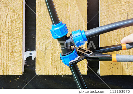 Adjustable wrench pliers is used to tighten fastening nut of compression clamp of triple pipe fitting when installing external drinking and irrigation water supply from HDPE pipes. Adjustable wrench pliers is used to tighten fastening nut of compression clamp of triple pipe fitting when installing external drinking and irrigation water supply from HDPE pipes. 113163970