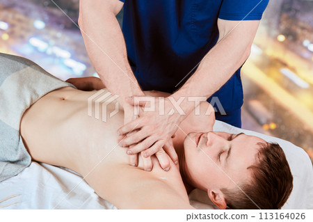Masseur doing deep tissue chest massage for men. Masseur doing deep tissue chest massage for men. 113164026