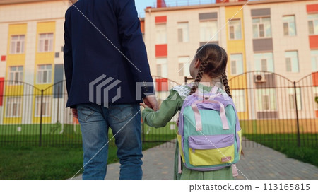 small child hand father hand. father leads child daughter hand school. large children school building. teaching children education. child parent school lesson. children time study. kid backpack. kid 113165815