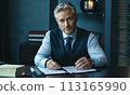 businessman, face of a blue-eyed gray-haired man, business concept, man smiling, head office employee, friendly employer, businessman sitting at his desk, gray-haired handsome man in a jacket smiling 113165990