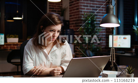 Employee calls manager remotely using internet videocall to ask for feedback on project progress. Worker in brick wall office requesting assistance from team leader in teleconference meeting, camera A 113168219