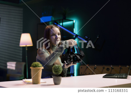 Tech content creator filming technology review of newly released VR glasses, unboxing them and presenting specifications to audience. Influencer showing virtual reality device to subscribers 113168331