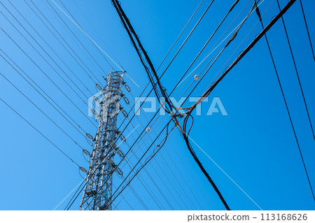 高壓輸電塔、城市交叉電力線和晴朗的天空 A-1 113168626