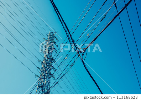 高壓輸電塔、城市中交叉的電力線、晴朗的天空 A-3 暖色 113168628