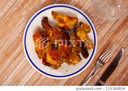 grill spicy buffalo wings on blue plate for lunch 113169934