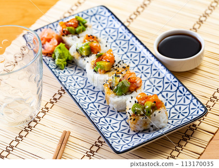 Saketaki roll served with soya sauce and wasabi in a plate 113170035