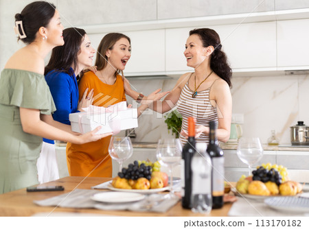 Three women have arrived for birthday celebration and presenting gift to birthday woman Three women have arrived for birthday celebration and presenting gift to birthday woman 113170182