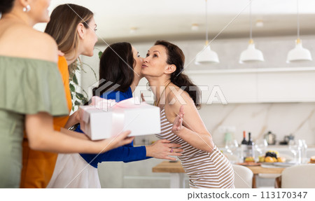 Group of women greeting each other and giving gift Group of women greeting each other and giving gift 113170347