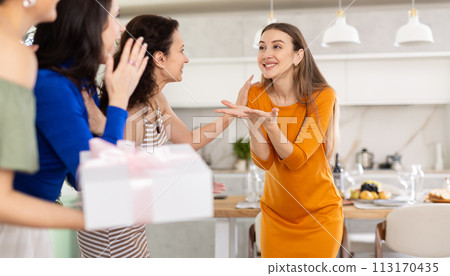 Three women have arrived for birthday celebration and presenting gift to birthday woman Three women have arrived for birthday celebration and presenting gift to birthday woman 113170435