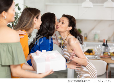 Group of women greeting each other and giving gift Group of women greeting each other and giving gift 113170459