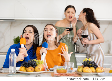 Group of women friends singing karaoke Group of women friends singing karaoke 113170490