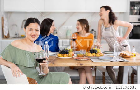 Happy Kazakh girl sitting in front of friends group, with her back to speakers. Happy Kazakh girl sitting in front of friends group, with her back to speakers. 113170533