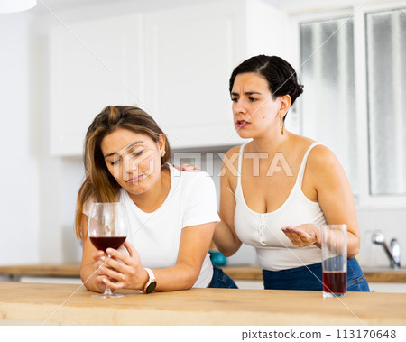 Sadness woman has problem, girlfriend consoling her at table in kitchen 113170648