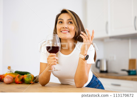 Happy housewife preparing vegetable salad and drinking red wine Happy housewife preparing vegetable salad and drinking red wine 113170672