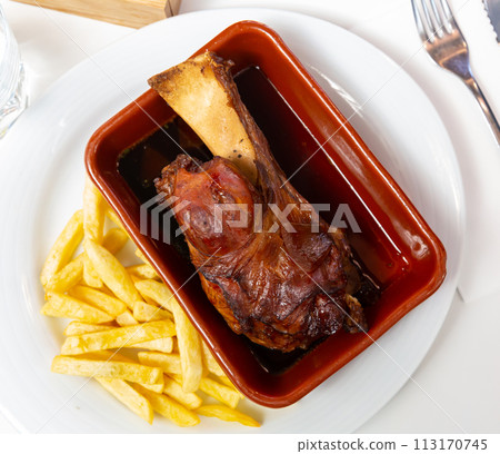 Oven baked pork knuckle with french fries on plate Oven baked pork knuckle with french fries on plate 113170745