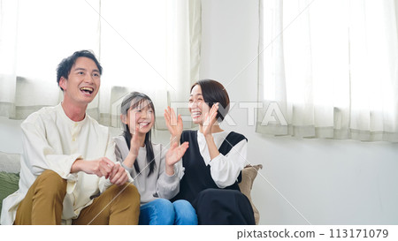 Parents and children happy while watching TV in the living room Parents and children happy while watching TV in the living room 113171079