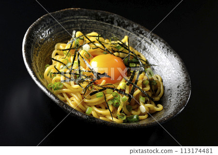 Abura-soba noodles topped with egg yolk, shredded seaweed, and green onions photographed against a black background Abura-soba noodles topped with egg yolk, shredded seaweed, and green onions photographed against a black background 113174481