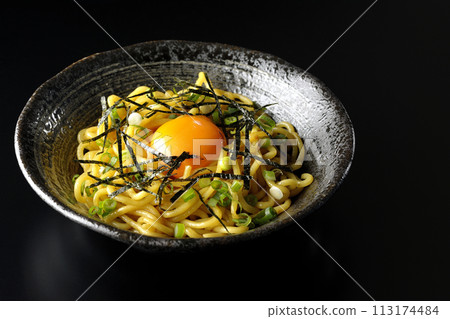 黑色背景下拍攝的油蕎麥麵，上面有蛋黃、切碎的海藻和蔥 113174484