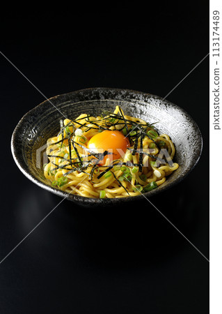 Abura-soba noodles topped with egg yolk, shredded seaweed, and green onions photographed against a black background Abura-soba noodles topped with egg yolk, shredded seaweed, and green onions photographed against a black background 113174489