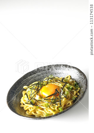 Abura-soba noodles topped with egg yolk, shredded seaweed, and green onions photographed against a white background 113174538