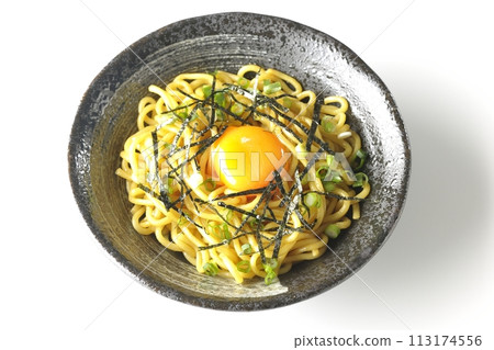 Overhead shot of abura soba topped with egg yolk, chopped seaweed, and small onions against a white background Overhead shot of abura soba topped with egg yolk, chopped seaweed, and small onions against a white background 113174556