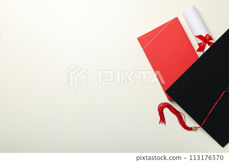 A graduate's hat and books, on a light background. 113176570