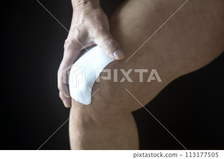 Poultice applied to the knee of an elderly man suffering from knee pain 113177505