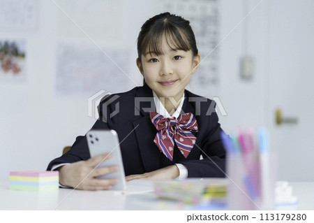 Portrait of a female student studying with a smartphone in hand 113179280