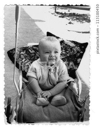 Vintage photo of a boy in a stroller. The child smiles. Photo from 1961. 113180450