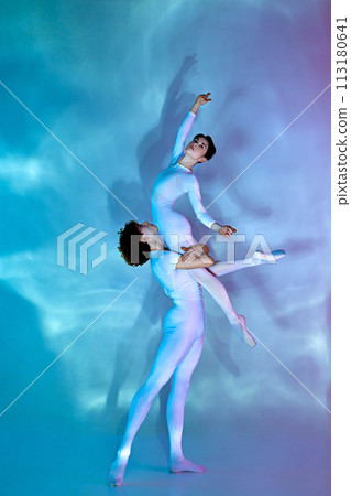 Artistic, talented male and female ballet dancers in pastel leotards performing lift against gradient background. Artistic, talented male and female ballet dancers in pastel leotards performing lift against gradient background. 113180641
