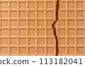 Broken spelt waffle with grid pattern as background 113182041
