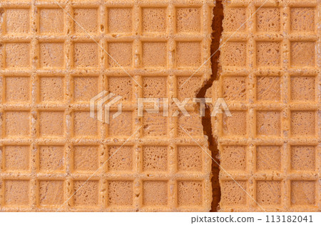 Broken spelt waffle with grid pattern as background 113182041
