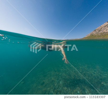 Young male on holidays enjoy floating on a crystal clear water beach of Antalya Turkey. Man swimming with open arms. Relax and tranquility 113183307