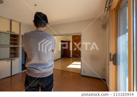 A man looks at his room after sorting out his belongings from his parents' house and carrying out all the belongings inside. A man looks at his room after sorting out his belongings from his parents' house and carrying out all the belongings inside. 113183934