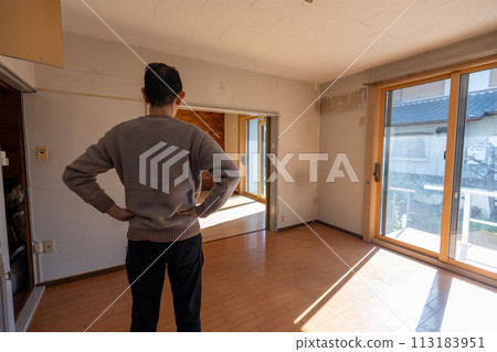 A man looks at his room after sorting out his belongings from his parents' house and carrying out all the belongings inside. A man looks at his room after sorting out his belongings from his parents' house and carrying out all the belongings inside. 113183951