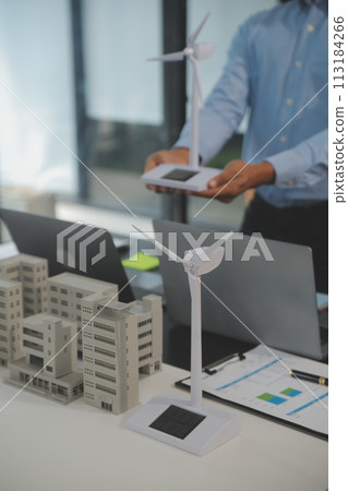 Close-up at tablet, Engineers pointing at tablet with their hands. To jointly design the use of renewable energy with wind and solar energy. Concept of using renewable energy. 113184266