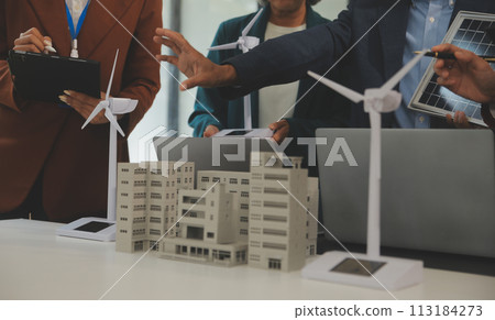 Close-up at tablet, Engineers pointing at tablet with their hands. To jointly design the use of renewable energy with wind and solar energy. Concept of using renewable energy. 113184273