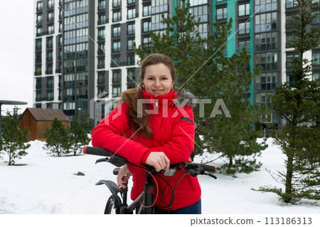 A young woman went on a winter bike ride around the city 113186313