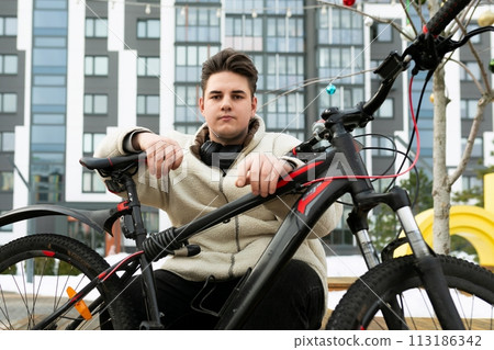 A handsome young guy stopped to rest while cycling 113186342